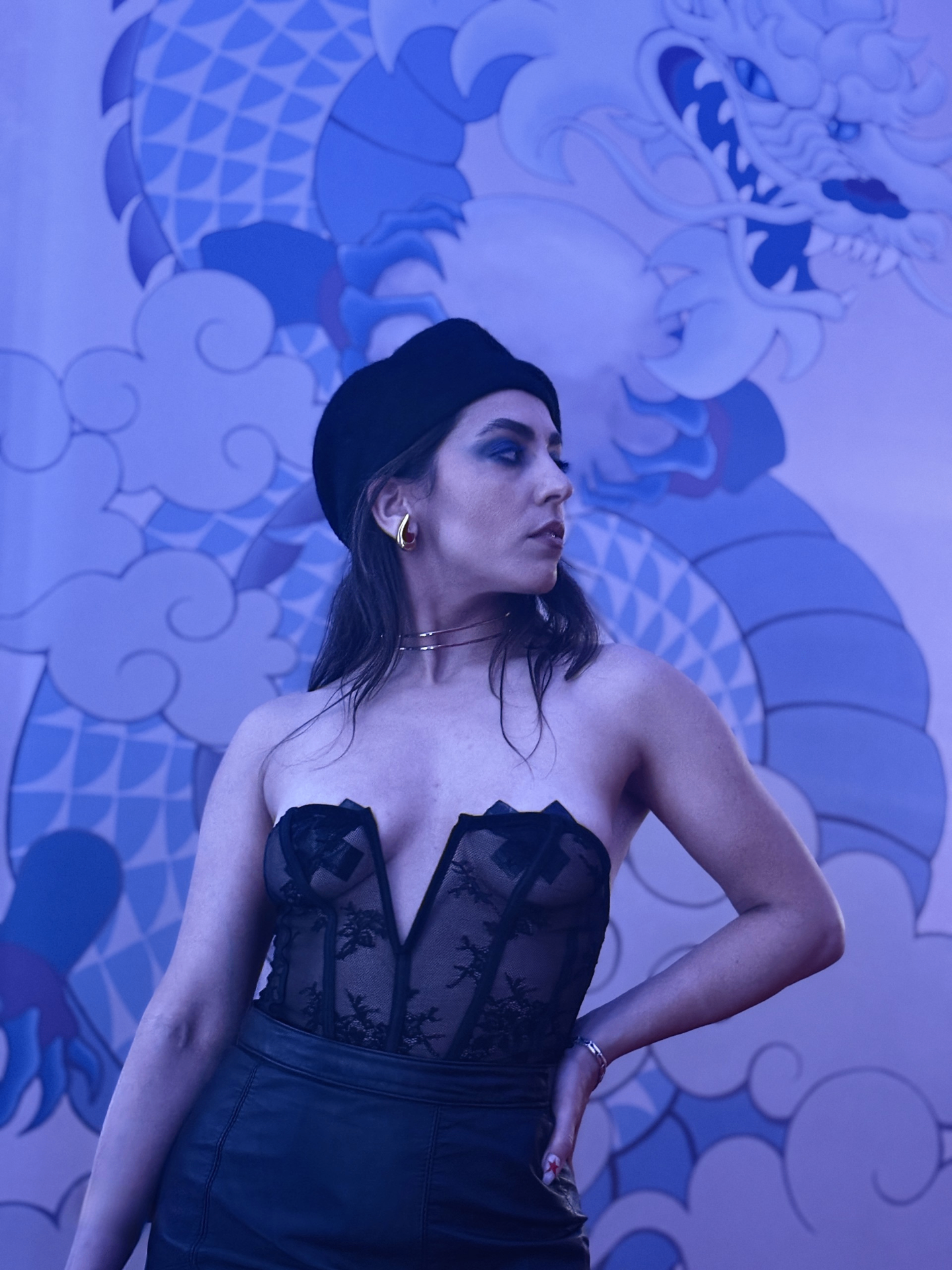 Iron Geisha × Monty Monsterslayer collab — model in black corset against a blue dragon mural